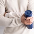 A male holding a Personalized Ever Vessel Multi Blue stainless steel tea infuser water bottle with laser engraved text Michael on the lid.