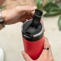A male holding an Ever Vessel Super Maxi Red stainless steel water bottle with the flip top lid open.