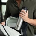 A male putting his Ever Vessel Super Maxi stainless steel water bottle into his commuter backpack.