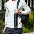A male carrying his Ever Vessel Super Maxi Black stainless steel water bottle by the integrated handle at university.