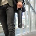 A male carrying his Ever Vessel Super Maxi Black stainless steel water bottle by the integrated handle to work.
