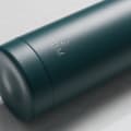 Personalized Ever Vessel stainless steel water bottle in teal green with laser engraved text MJM and emoji on the side.