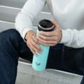 A male holding an Ever Vessel Super Maxi Mint green stainless steel water bottle with the flip top lid open.