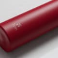 An Ever Vessel Mini Red  Personalized small water bottle with a name Tom and plane emoji engraved on the side.