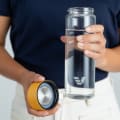 A female about to drink from her Ever Vessel Glass water bottle with yellow lid removed.