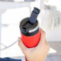 A male about to drink from his Ever Vessel Maxi Red stainless steel water bottle with leak-proof flip lid open on a yacht.