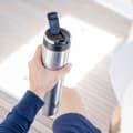 A male about to drink from his Ever Vessel Super Maxi stainless steel water bottle with leak-proof flip lid open on a yacht.