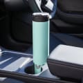 An Ever Vessel Super Maxi Mint stainless steel water bottle sitting in a car cup holder.