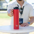 A male about to grab his Ever Vessel Super Maxi Red stainless steel water bottle from a bar table at an event.