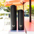 An Ever Vessel Super Maxi and Maxi Black stainless steel water bottles sitting on an outside table.