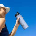 A female about to drink from her Ever Vessel Maxi Lilac stainless steel water bottle with the leak-proof flip top open.