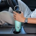 Male inserting his Ever Vessel Maxi Mint stainless steel water bottle into a car cup holder.