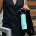 Female carrying her Ever Vessel Maxi Mint Green stainless steel water bottle by the integrated carry handle at the office cafeteria.