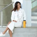 A female sitting next to her Ever Vessel Maxi yellow stainless steel water bottle outside of the work office.