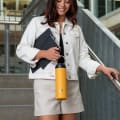 Female carrying her Ever Vessel Maxi Yellow stainless steel water bottle by the integrated carry handle at the office.