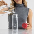 A female filling her Ever Vessel Glass water bottle with red lid at the office.
