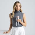 A female holding her Ever Vessel Glass water bottle with rose pink lid at work.