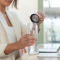A female about to drink from her Ever Vessel Glass Multi double walled glass tea infuser bottle with the rose pink lid removed.