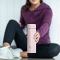 Female at the gym lifting an Ever Vessel Multi Rose pink tea infuser water bottle.