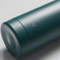 Personalized Ever Vessel stainless steel water bottle in teal green with laser engraved text MJM and emoji on the side.