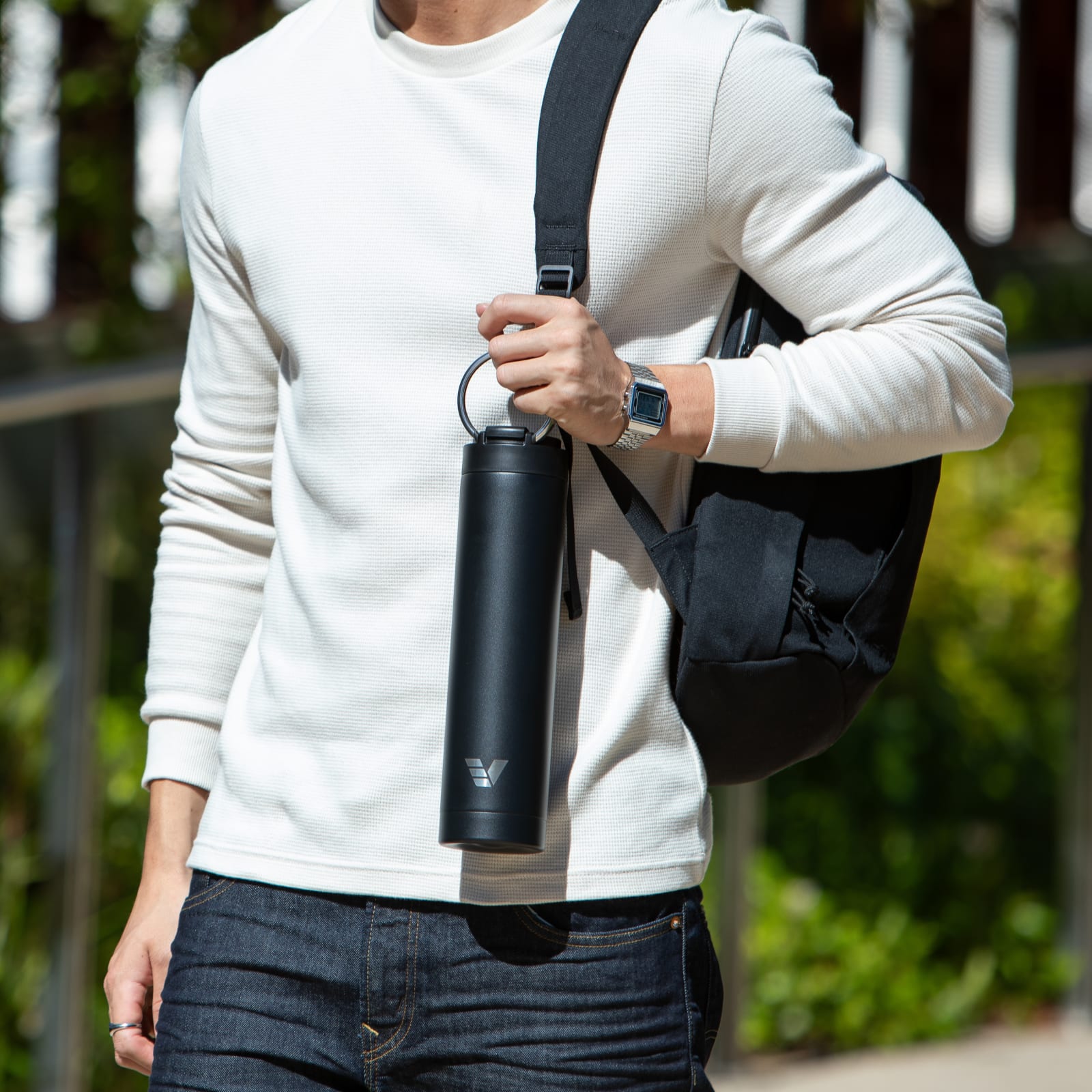 A male carrying his Ever Vessel Super Maxi Black stainless steel water bottle by the integrated handle at university.