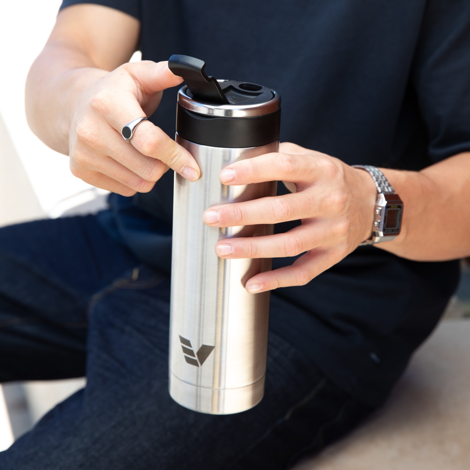 A male opening the flip top lid on his Ever Vessel Maxi stainless steel water bottle.