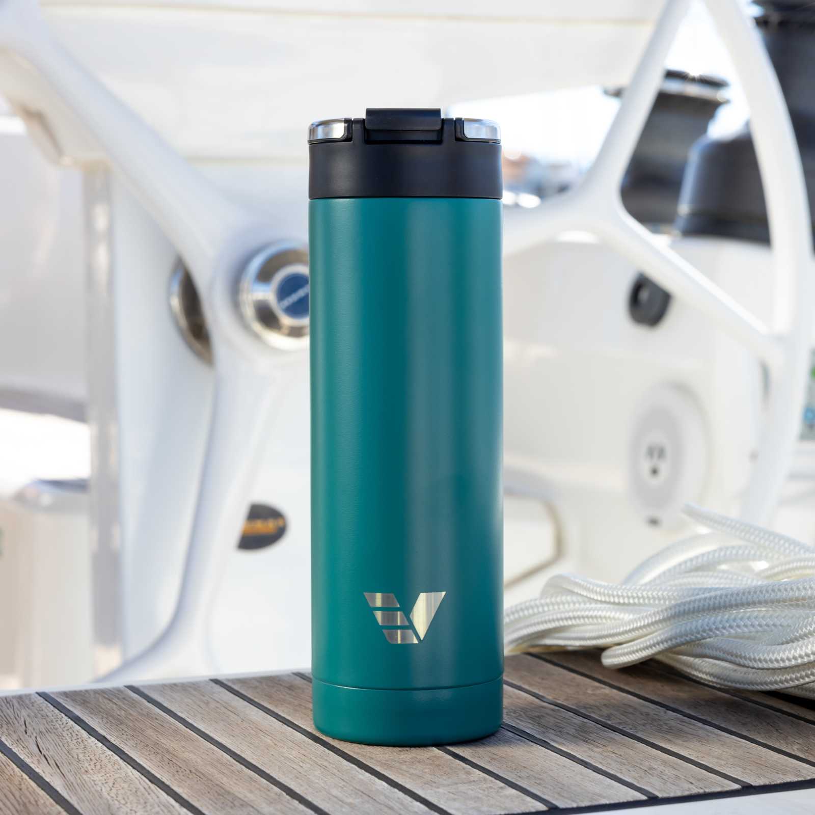 An Ever Vessel Maxi Teal Green stainless steel water bottle on the deck of a yacht.