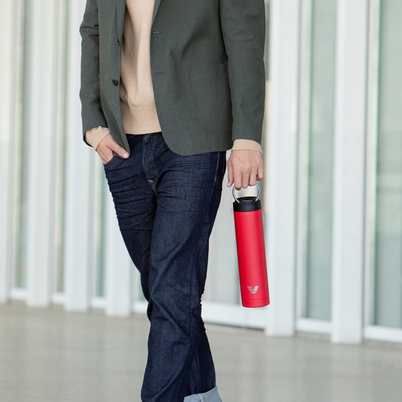 A male carrying his Ever Vessel Super Maxi Red stainless steel water bottle by the carry handle on the way to work.