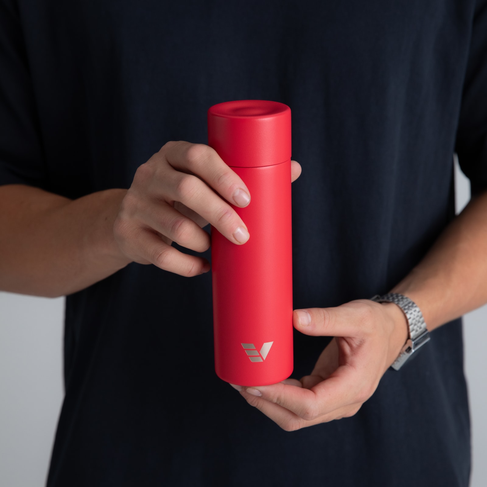 A male holding his Ever Vessel Mini Red small water bottle.