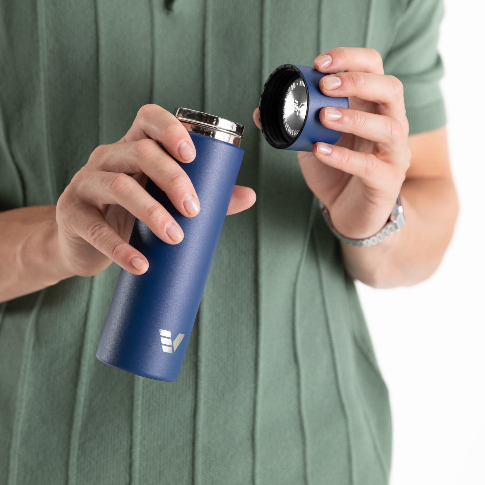 Male about to drink from an Ever Vessel Mini Blue small water bottle with the lid off.
