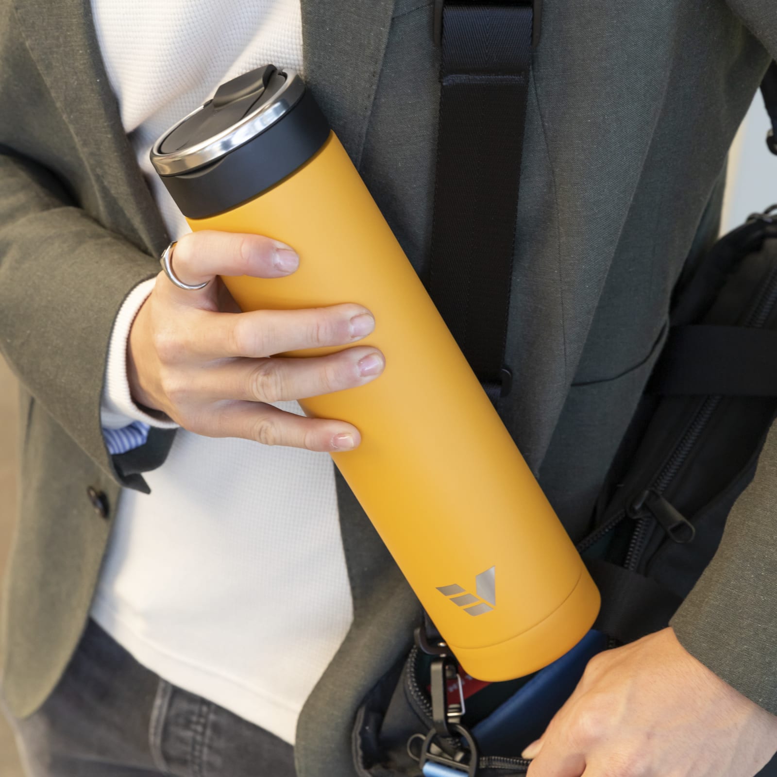 A male putting his Ever Vessel Super Maxi yellow stainless steel water bottle into his workbag.