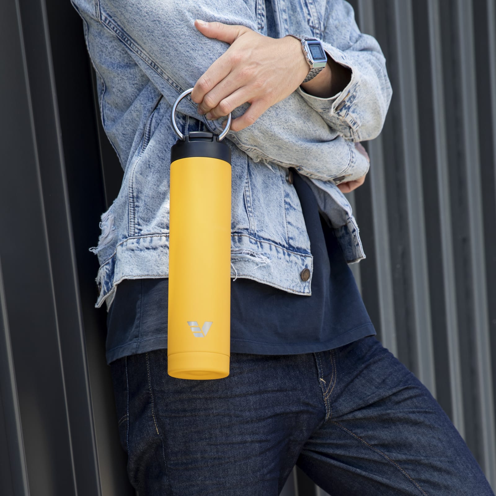 Male carrying his Super Maxi Yellow stainless steel water bottle by the integrated handle.