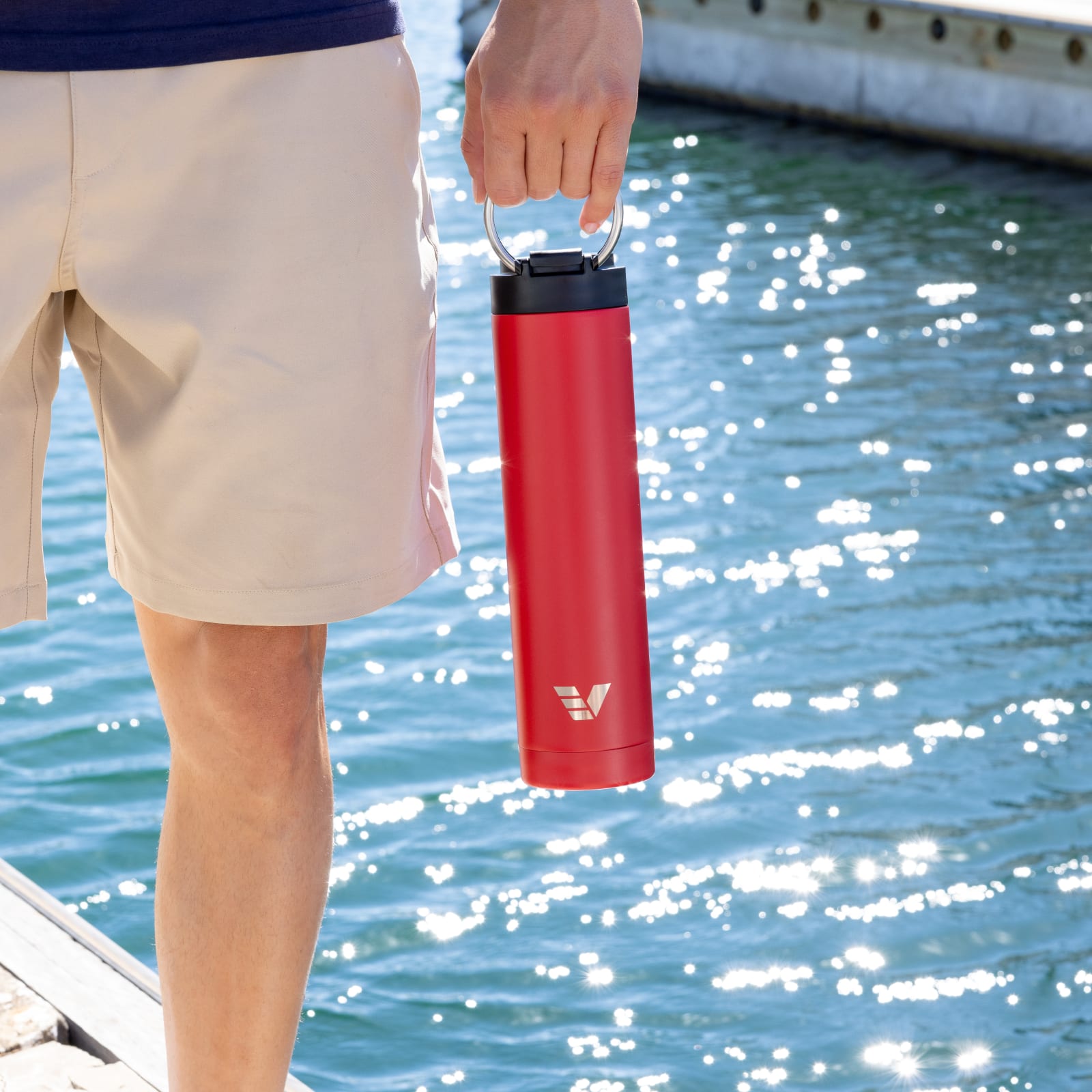 Ever Vessel Red Super Maxi insulated water bottle being held by handle on a jetty