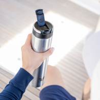 A male about to drink from his Ever Vessel Super Maxi stainless steel water bottle with leak-proof flip lid open on a yacht.