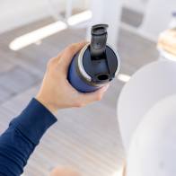 A male about to drink from his Ever Vessel Maxi Blue stainless steel water bottle with leak-proof flip lid open on a yacht.