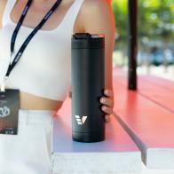 A female holding her Ever Vessel Maxi Black stainless steel water bottle at an event.