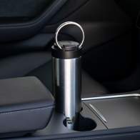 An Ever Vessel Maxi stainless steel water bottle sitting in car cup holder with integrated carry handle deployed.