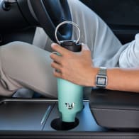 Male inserting his Ever Vessel Maxi Mint stainless steel water bottle into a car cup holder.
