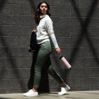 Female carrying her Ever Vessel Maxi Rose pink stainless steel water bottle by the integrated carry handle on the way to work.