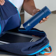 A male packing his Ever Vessel Multi Blue stainless steel tea infuser water bottle into his backpack.