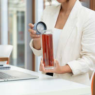 A female about to drink from her Ever Vessel Glass Multi double walled glass tea infuser bottle with the lilac lid removed.