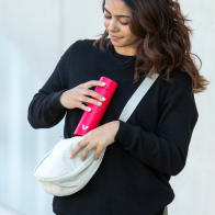 A female putting her Ever Vessel Mini Red small water bottle into a small sling.