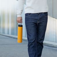 Male carrying his Super Maxi Yellow stainless steel insulated water bottle by the carry handle.