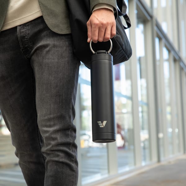 A male carrying his Ever Vessel Super Maxi Black stainless steel water bottle by the integrated handle to work.