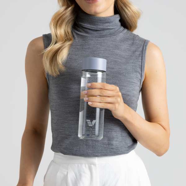 A female holding her Ever Vessel Glass water bottle with lilac lid at work.
