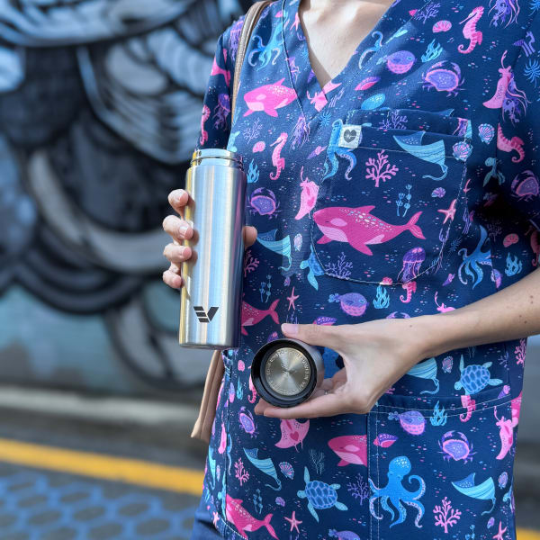 Ever Vessel Stainless Steel Mini Water bottle with no paint held by female nurse with lid off