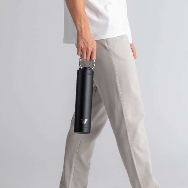 Male with an Ever Vessel Super Maxi Black Sand stainless steel water bottle, holding with the integrated handle