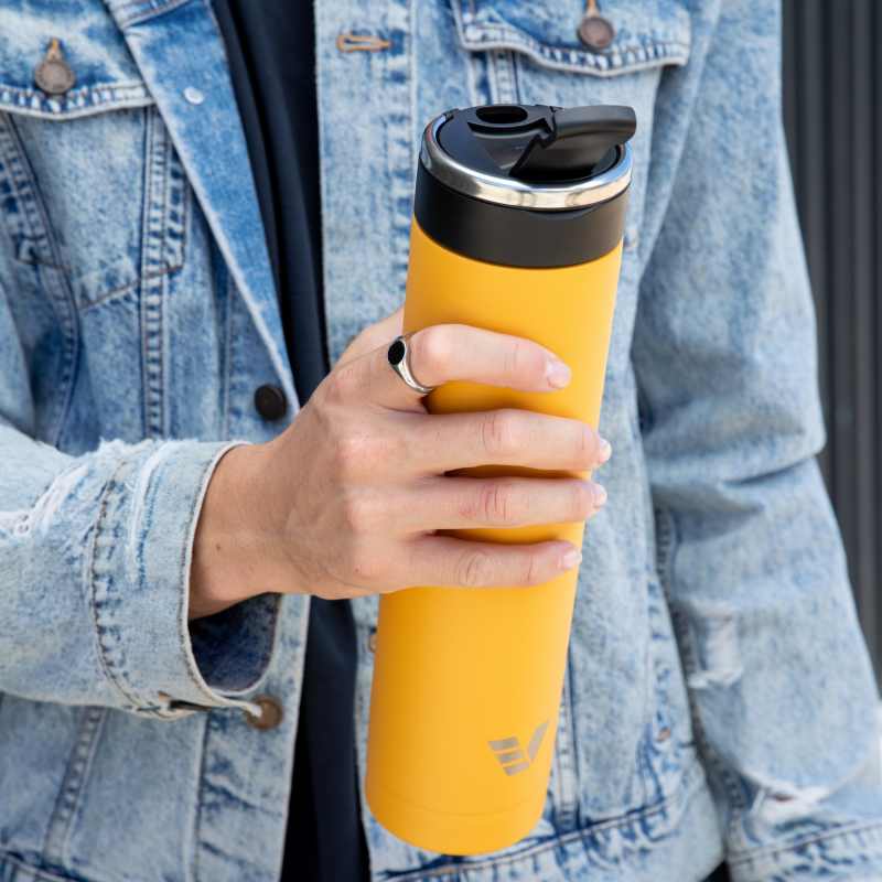A male holding an Ever Vessel Super Maxi Yellow stainless steel water bottle with the flip top lid open.