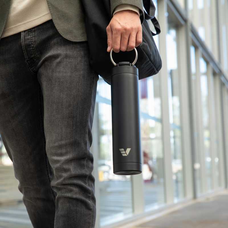 A male carrying his Ever Vessel Super Maxi Black stainless steel water bottle by the integrated handle to work.
