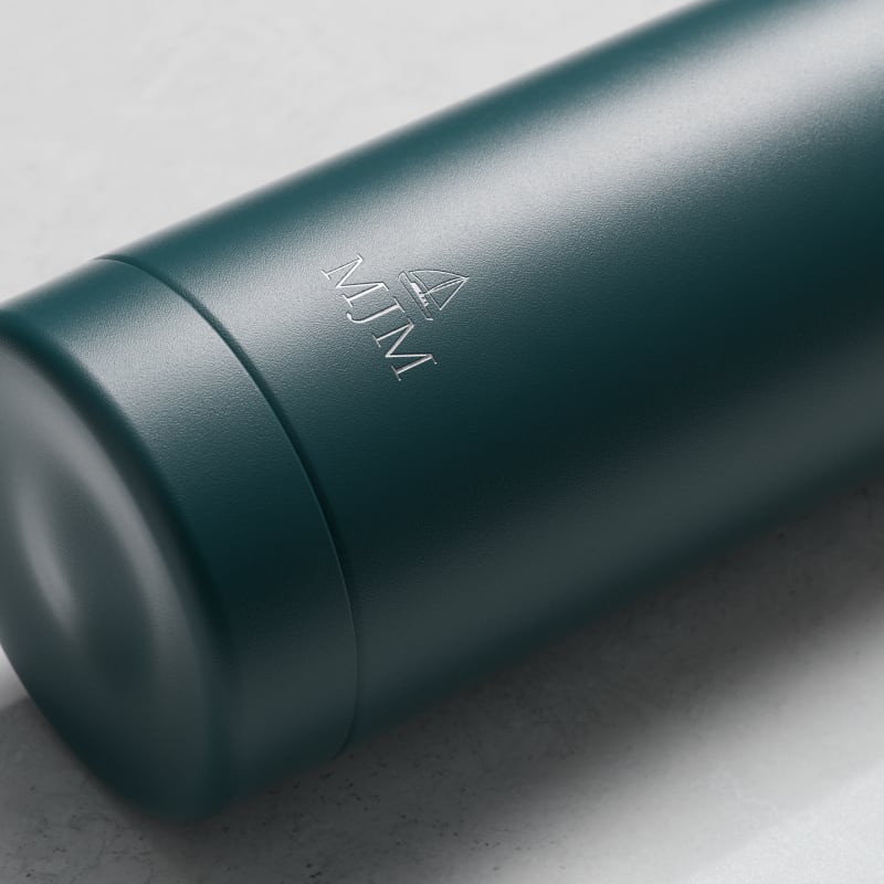 Personalized Ever Vessel stainless steel water bottle in teal green with laser engraved text MJM and emoji on the side.